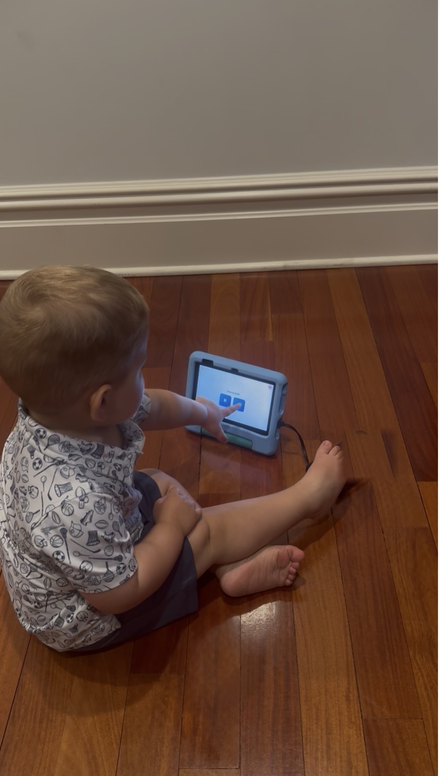 A toddler independently tapping through a Training Minds lesson on a tablet